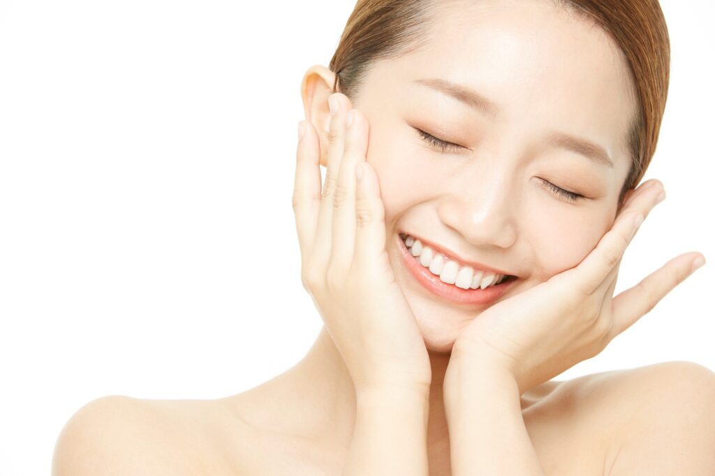 肌に触れて笑顔の女性患者